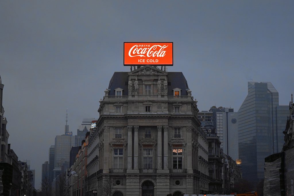 uz ēkas coca colas reklāmas baneris