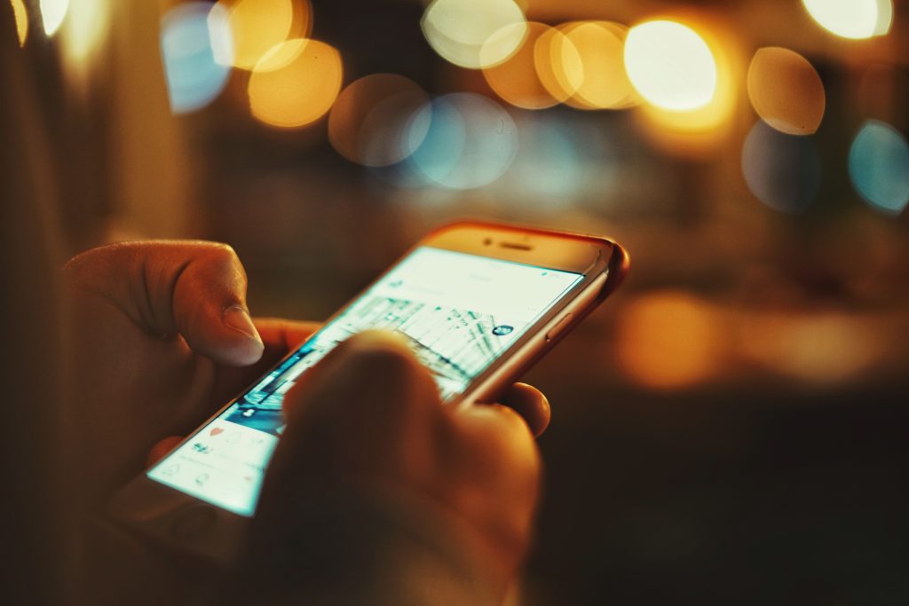cilvēks skatās savu instagram uz ielas